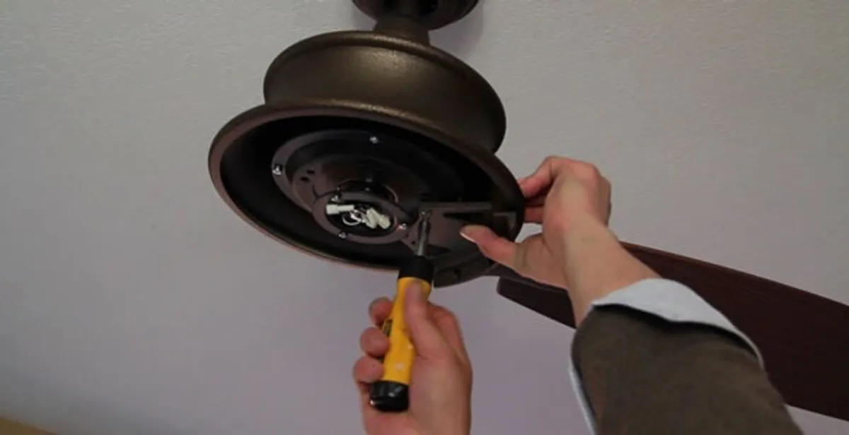Electrician installing ceiling fan mounting bracket and fixture in Chandler, AZ