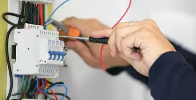 Electrician installing and adjusting circuit breakers in an electrical panel in Chandler, AZ
