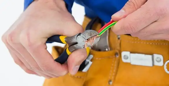 licensed electrician securing electrical wiring with professional tools during service work in Chandler, AZ