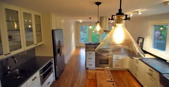 Residential electrician installing modern indoor light fixture in a home in Chandler, AZ